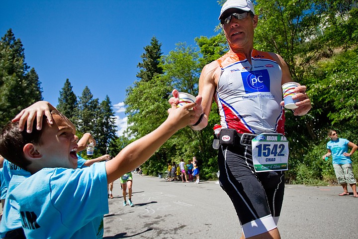 &lt;p&gt;SHAWN GUST/Press Jacob Donovan, 7, hands a cup of water to Ironman competitor Chad Bustos Sunday at an aid station where the Coeur d'Alene child was volunteering with the five other members of his family.&lt;/p&gt;