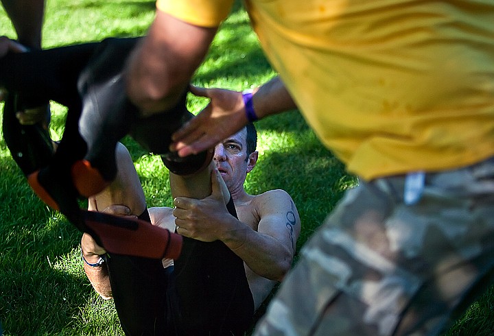 &lt;p&gt;BEN BREWER/Press Brad Brenner of Austin, TX watches as volunteers rip the wetsuit off his feet during the transition stage.&lt;/p&gt;