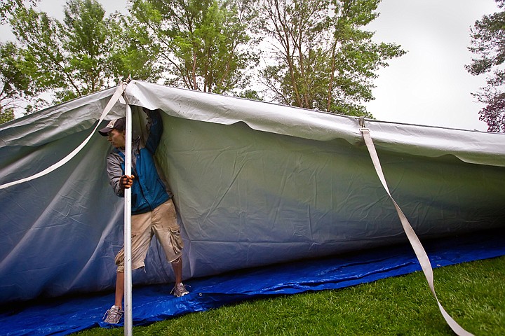 &lt;p&gt;JEROME A. POLLOS/Press Matt Rud, from Winona, Minn., stabilizes a support while other workers begin to secure the edges of a tent in the Ironman Village that began construction Monday in City Park.&lt;/p&gt;