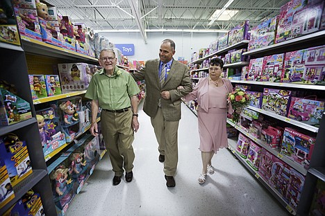 &lt;p&gt;Store manager Ardie Wardell, center walks the bride, Lois Free, and the groom, Donald Evans, down the aisle &#151; the toy aisle &#151; prior to the couple's wedding.&lt;/p&gt;