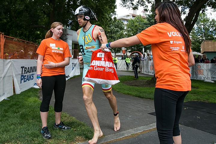 &lt;p&gt;JAKE PARRISH/Press&lt;/p&gt;&lt;p&gt;Volunteer Felicia Tuck watches as Allison Goss-Goal hands professional triathlete Chris Bagg his running gear bag as he transitions from biking to running during Sunday's Ironman race.&lt;/p&gt;