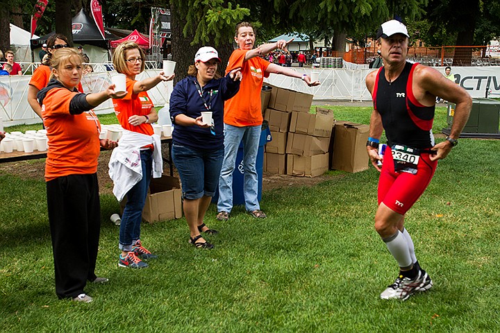 &lt;p&gt;MIKE CURRY/Press&lt;/p&gt;&lt;p&gt;Jeff Crosby, of Kirkland, Washington, is guided by volunteer Karen Laramie, far right, to a restroom in the bike-to-run transition. Offering water to athletes are volunteers, from left, Mikayla Geraphty, Julie Geraphty and Cat Grahm.&lt;/p&gt;