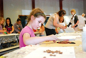 Molly Kate Sullivan, of Dixon, concentrates on finding the right colored beans for her lady bug mosaic.