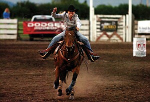 Darct Eickhoff, of Charlo, kicks her horse into high gear at the end of her run during the barrel-racing event of the Mission Mountain PRCA Rodeo last weekend in Polson.