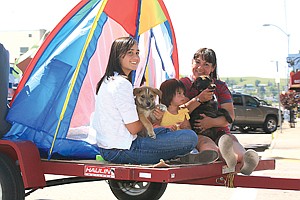 Kaitlyn Quinones, Chenoa Villegas and Susen Villegas ride with Shun and Mayuk, Akita-Huskie puppies in the Pet Parade in Polson Friday. The Villegas adopted the two puppies from a litter of nine that was pulled from an abandoned home in Arlee. Many of the puppies are still in need of a good home. Contact the Leader for more information.