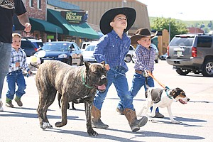 Gavin Knutson, 6, walks his Italian mastiff Lilly, while 3-year-old Ryle Lytle tends to his Walker Hound Hobey during Friday's pet parade.