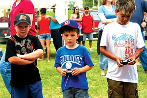 Rem Bell, Landry Leishman and Brandon Hanlon give remote control car racing a try at Saturday&#146;s annual picnic in St. Ignatius. People from around the valley and beyond came to enjoy the day.