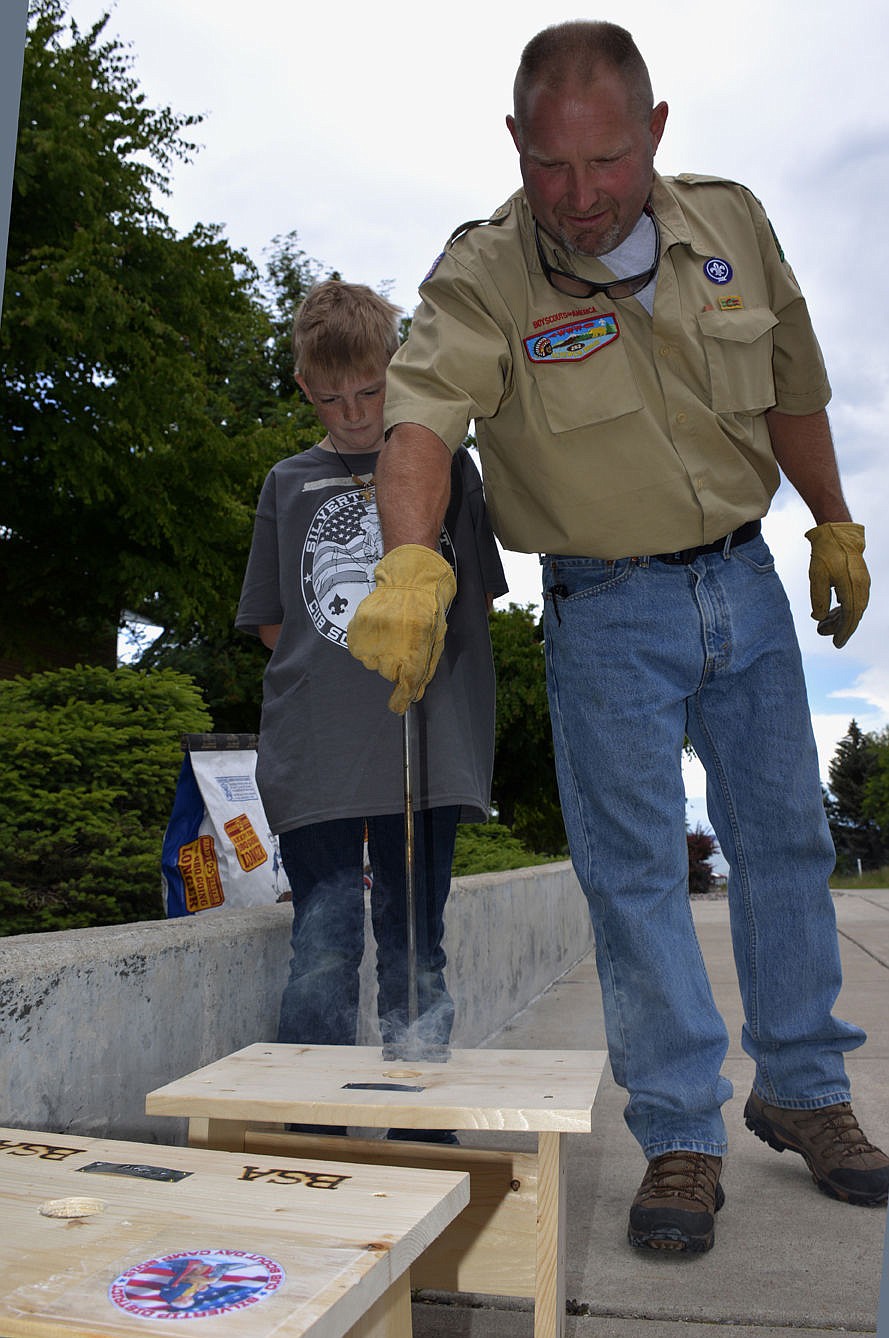 &lt;p&gt;&lt;strong&gt;Webelos Scout Cooper Clark watches Cub Master Rob Dotson brand a Boy Scouts logo onto the side of his freshly-made bench.&lt;/strong&gt;&lt;/p&gt;&lt;p&gt;&lt;strong&gt;&#160;&lt;/strong&gt;&lt;/p&gt;