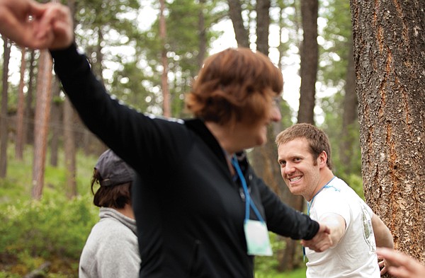 <p>Twenty-Three-year-old volunteer Adam Colvin, right, from Helena helps a camper at the For One Another Family Camp on the tightrope obstacle in Kalispell on June 22. Colvin attended camp for the first time in 2006 when his father was diagnosed with cancer.</p>