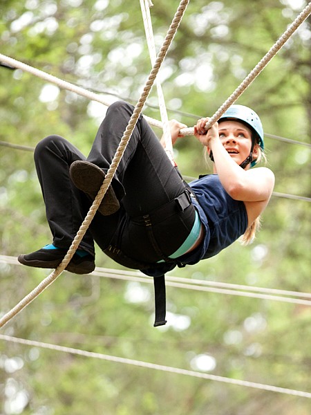<p>Fourteen-year-old Sidney Kiefer from Billings inches her way along the high ropes on Friday June 22. Kiefer attended the camp with her mother and sisters.</p>