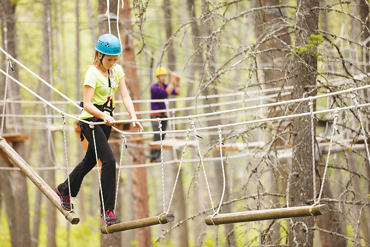 <p>Shaelyn Bachini from Billings walks across a high ropes obstacle at the For One Another Family Camp in Kalispell on June 22. Campers had a number of obstacles to choose from once they made their way up the first tree.</p>