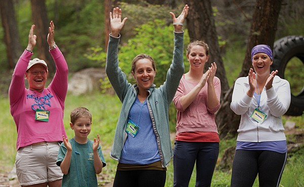 <p>Participants at the For One Another Family Camp celebrate after completing a maze obstacle in Kalispell on June 22. The camp is designed to celebrate life, family time, discover new strategies and hope with other families who have a cancer diagnosis.</p>
