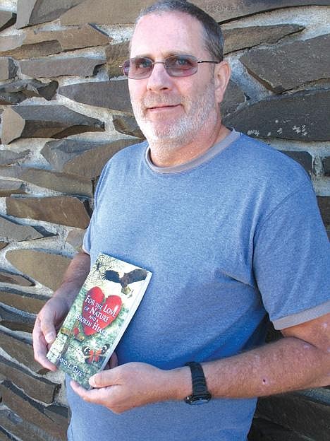 Matthew Weaver/Columbia Basin HeraldMoses Lake poet David L. Geer holds up a copy of his recently published book, "For the Love of Nature and a Broken Heart."