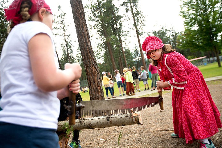 &lt;p&gt;JAKE PARRISH/Press Dressed in pioneer garb, Ponderosa Elementary School fourth grader Trinity Meurs works a crosscut two-person hand saw with classmate Sidney Perry on Thursday at the logging station at the Pat Triphahn Memorial Rendezvous. Students also had the opportunity to ride horses, cast fishing poles, sing campfire songs, learn about the lives of frontiersman and other facets of life in Idaho in the 1800s.&lt;/p&gt;