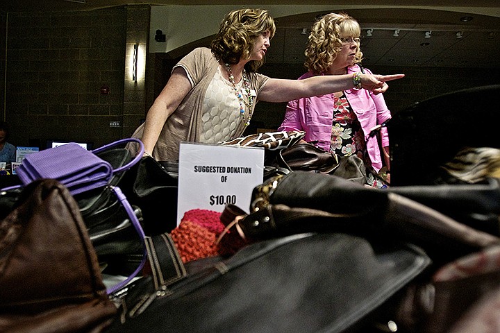 &lt;p&gt;JEROME A. POLLOS/Press Cathy Miller Penley, left, a board member of the Dirne Community Health Center, assists Mary Jo Sauber in locating a purse Wednesday during the Purse with a Purpose fundraising event at the Coeur d'Alene Public Library. The event was a fundraiser for Dirne Community Health Center to promote preventative health care for uninsured women.&lt;/p&gt;