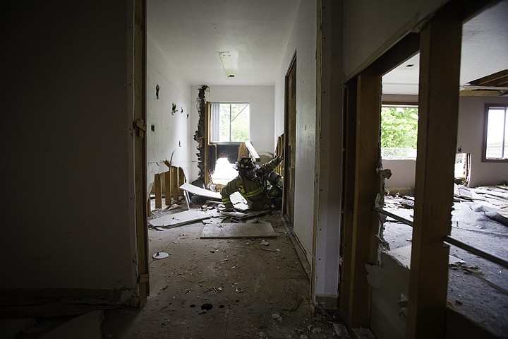 &lt;p&gt;SHAWN GUST/Press Josh Sutherand, a firefighter with the City of Coeur d'Alene Fire Department, crawls through a hole in a wall Friday after performing an interior wall breech during a training exercise at the former Coeur d'Alene School District administration office. The district allowed emergency crews to use the building for training before its scheduled demolition&lt;/p&gt;