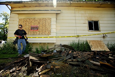 &lt;p&gt;Ed McElfresh, with Northwest Boardups, walks through debris after hanging an arson reward sign on a home destroyed by a fire early Friday morning.&lt;/p&gt;