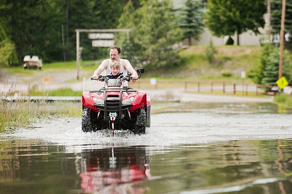 &lt;p&gt;A man and boy drive an all-terrain vehicle across the flooded
causeway at Echo Lake on Tuesday afternoon. The causeway was dry
late last week, but rising water in the lake now covers the
roadway.&lt;/p&gt;