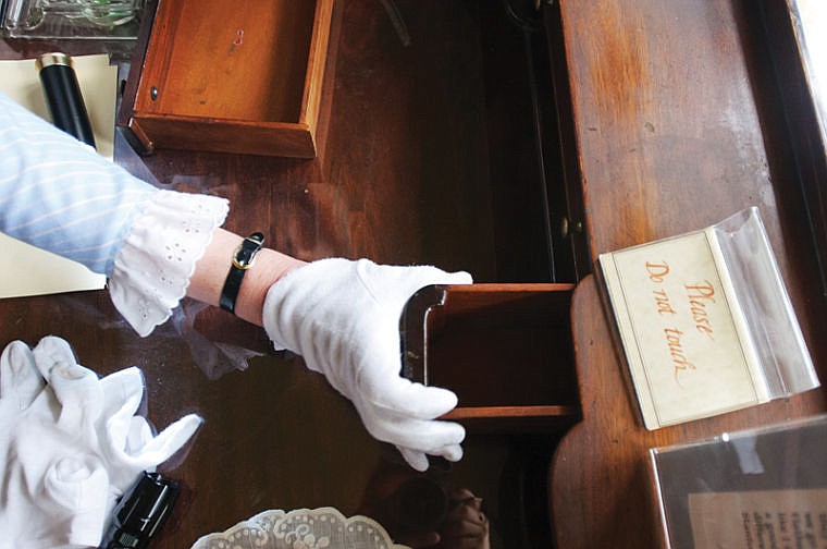 <p>Tour guide Mary Miers shows off one of the secret compartments in Charles Conrad's desk at the Conrad Mansion. (Patrick Cote/Daily Inter Lake)</p>