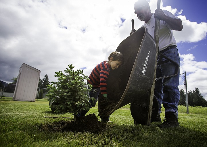 &lt;p&gt;SHAWN GUST/Press Rich Dussell, a real estate agent with Windermere Coeur d'Alene Realty, steadies a wheelbarrow as Jack Jenkins, 5, unloads soil Friday while planting a blue spruce at Children's Village in Coeur d'Alene. Nearly 100 agents and staff worked on site to make improvement to facilities and the surrounding grounds as part of the real estate company's Community Service Day. The work was made possible through volunteer labor and donations from Windermere Coeur d'Alene Realty, North Idaho Building Contractors Association, Gibbs Lumber, New Leaf Nursery, Pioneer Title, First American Title, Eagle Ridge Builders, Termac Construction, Daryl Elmore, Northland Nursery and Kootenai Title.&lt;/p&gt;