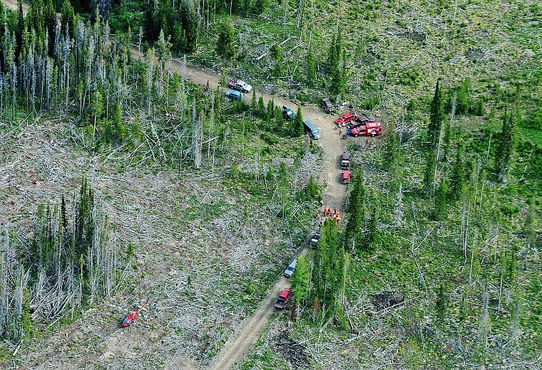 Crews gather Thursday morning on a forest road in Sanders County about two miles away from the site of a plane crash near Dixon. They were preparing for an arduous trek to retrieve four victims of Sunday&#146;s crash.