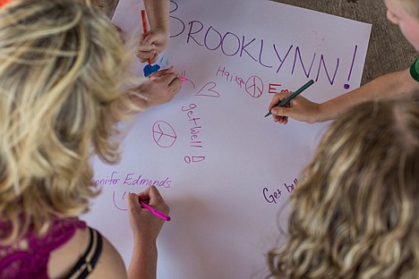 &lt;p&gt;Friends and school teachers scrawl supportive messages on a large get-well card for Brooklynne White at a fundraiser and card-making gathering for burn victims Brooklynne and Joshua Emerson on Wednesday in Bluegrass Park.&lt;/p&gt;