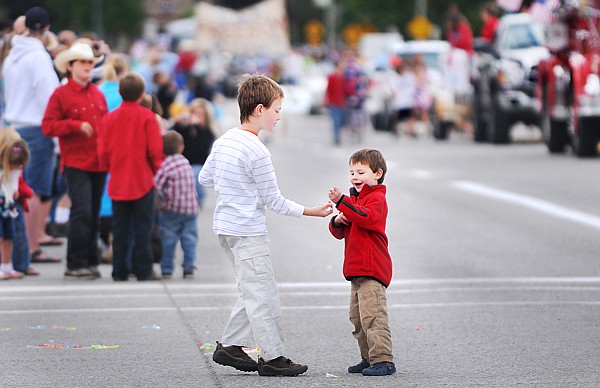 Sam Corbett, 3, right, smiles and shows off the candy he's collected to his brother Will Corbett, 8, on Saturday at the 4th of July Parade in Kalispell. The brothers live in Kalispell.