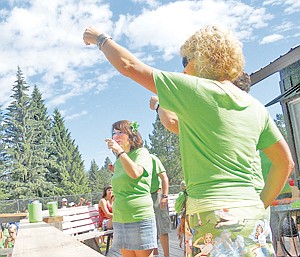 <p>Missy Chamberlain, Deb Kambel and Brooke Holzer lead the toast in Greg “Peach” Kambel’s honor, handing out shots of peach schnapps to all the participants.</p>