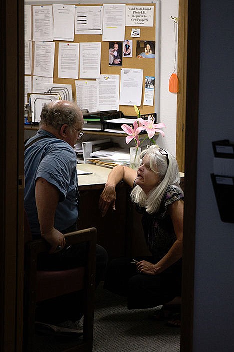 <p>Beth Poirier speaks with Sarah Street Apartments resident Fred Shalz, in her office Wednesday.</p>