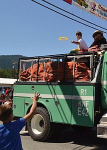 &lt;p&gt;A child along the Fourth of July parade reaches for a plastic flying-circle thrown his way by a U.S. Forest Service employee on the float.&lt;/p&gt;
