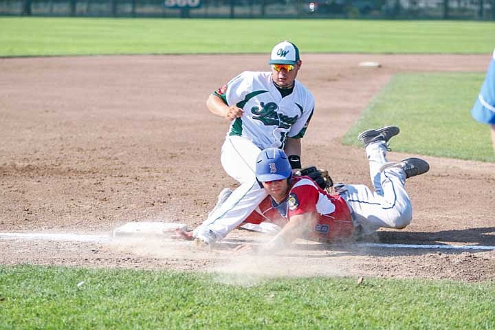 A Yakima runner eludes the tag of Gunner Raymond at third base.