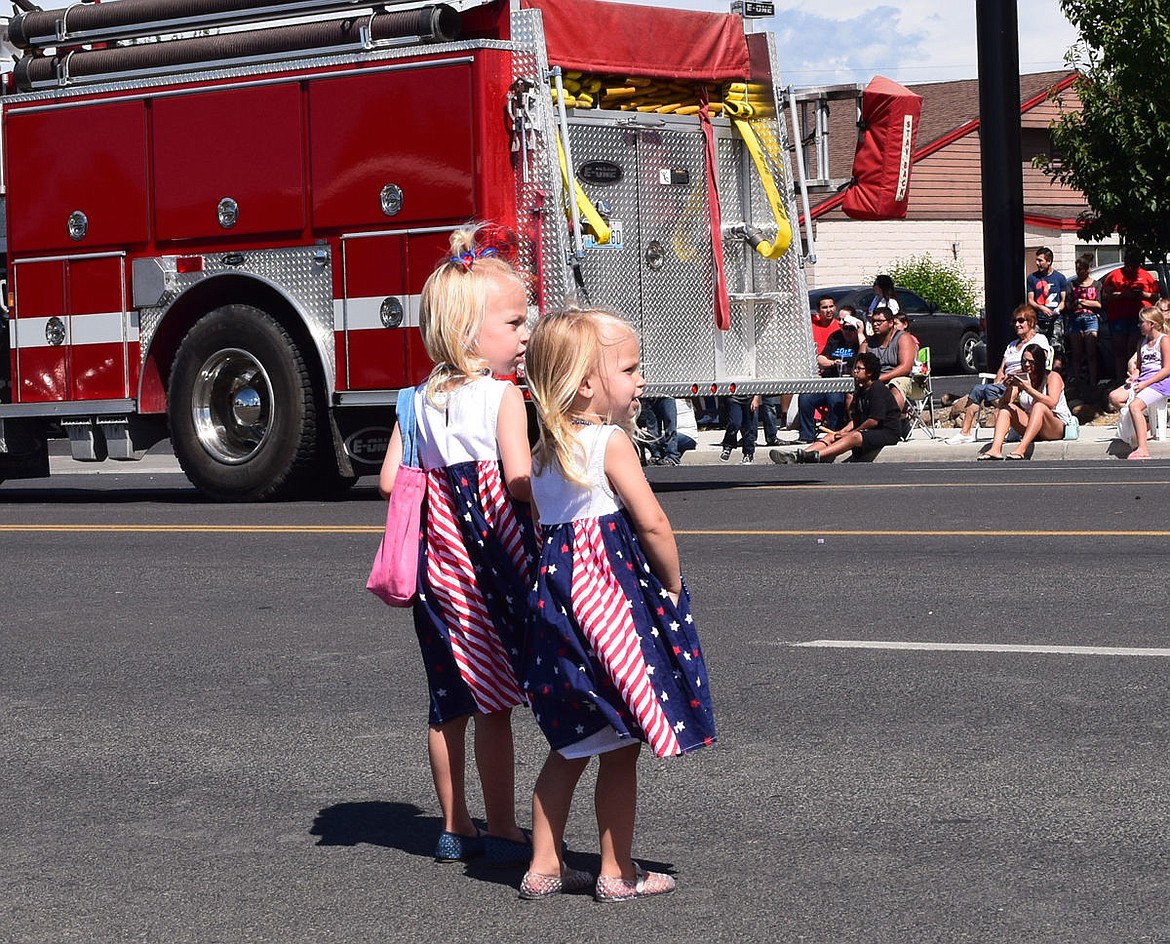 Brixley and Josie Phillips, ages 4 and 2, wait for the next rain of candy from a float in Othello's Fourth of July parade.