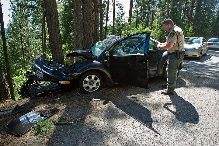 &lt;p&gt;SHAWN GUST/Press Kootenai County Sheriff's Deputy, Joel Gorham, surveys the scene of a single car accident Monday on Upriver Drive in Coeur d'Alene. One woman was transported to the hospital by emergency crews while a two dogs were killed. The cause of the incident was unclear and currently under investigation.&lt;/p&gt;