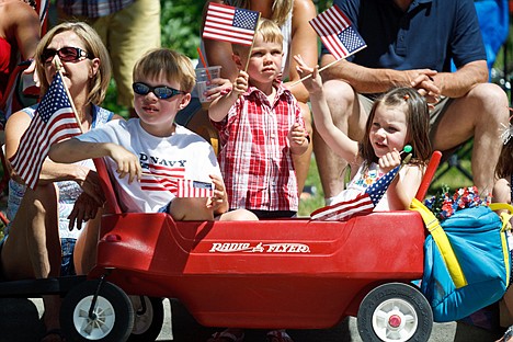 &lt;p&gt;Bridger Thurman, 7, far left, looks on as Alex McCall, 3, and Abbi McCall, 5, wave American flags during the parade in Coeur d'Alene.&lt;/p&gt;