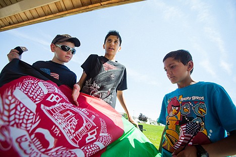 &lt;p&gt;Milad, 12, explains the meaning of the Afghanistan flag as Mansur, right, and Jon-Marc watch closely at a Coeur d'Alene park during a recent activity with Solace for the Children, a group organized to provide health and healing tools to children of Afghanistan.&lt;/p&gt;