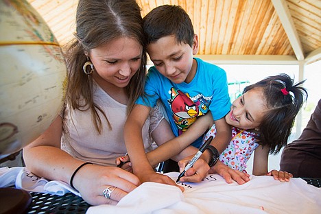 &lt;p&gt;Tracy Nielsen, of Coeur d'Alene, helps Afghan children Mansur and Suhila sign their names to a tee-shirt before tie-dying.&lt;/p&gt;