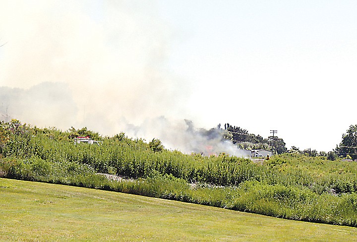 A Moses Lake resident watches a fire near Montlake Park Tuesday
afternoon. It was not immediately known if the fire was caused by
fireworks.