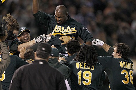 &lt;p&gt;Oakland's Chris Carter celebrates with teammates after hitting a three-run home run in the bottom of the 11th inning to lift the Athletics past the visiting Seattle Mariners 4-1 on Friday night.&lt;/p&gt;