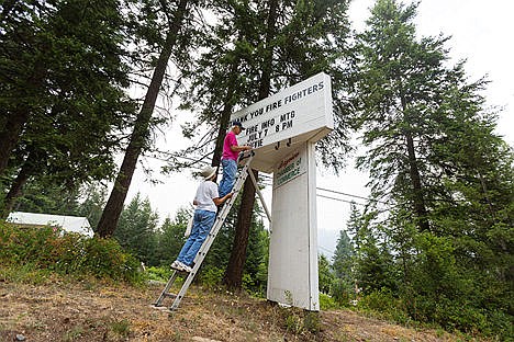 &lt;p&gt;Bruce and Judy Robinson, volunteers and members with the Bayview Chamber of Commerce, work together to place letters on a sign thanking firefighters and informing residents of a community fire information meeting.&lt;/p&gt;