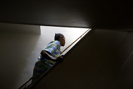 &lt;p&gt;This photo taken June 12 shows Alberta Hough, who suffers from Parkinson's disease, grasping a recently repaired banister as she makes her way up a staircase in her home in Baltimore.&lt;/p&gt;