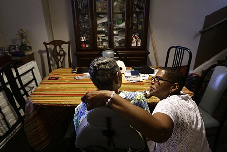 &lt;p&gt;Occupational therapist Ally Evelyn-Gustave, right, speaks with Alberta Hough, who suffers from Parkinson's disease, in Hough's home in Baltimore on June 12.&lt;/p&gt;