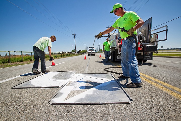 &lt;p&gt;Post Falls street maintenance worker Dan Beadles sprays street paint through a stencil as Josh Lupton sprinkles reflective glass beads onto a traffic arrow on Poleline Avenue. Street sealing and maintenance is the largest ongoing cost addressed in the city's proposed budget at nearly $194,000.&lt;/p&gt;