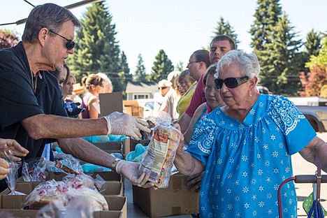 &lt;p&gt;Second Harvest Mobile Food Bank volunteer Lowell Nelson hands Arlene Nelson of Coeur d'Alene a bag of bagels at the food bank's distribution on Tuesday at Christ the King Lutheran Church. &quot;I get a nice selection of food here, from apples to bread to coffee,&quot; Luskin says. &quot;It's more than I can ask for.&quot; The mobile food bank distributed food to over 200 families.&lt;/p&gt;