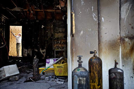 &lt;p&gt;Bryan Enos, co-owner of&Ecirc;SERVPRO of Coeur d'Alene, places a sheet of plywood over a garage doorway Friday at a home in the 100-block of Vista Way in Coeur d'Alene where the garage was destroyed by fire. A Coeur d'Alene Police officer kicked in the front door of the home to evacuate residents sleeping inside.&Ecirc;&lt;/p&gt;