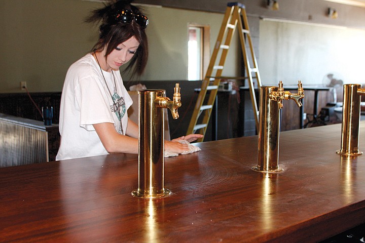 Jayme De Boer cleans the bar at Tymmy O'Shea's Irish Pub in
Moses Lake this week as the business prepares for a July 23
opening.