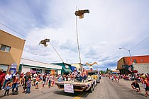 Eagles soar over Main Street in Polson, high above the 1st Citizen's Bank float during the Polson Fourth of July Parade.