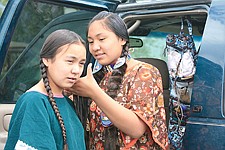 Maii Pete helps braid her sister Siliye's hair before the traditional dances began on Thursday's Old Style Day. Friday and Saturday, Siliye competed in the fancy dance, an art she has practiced since age 3.