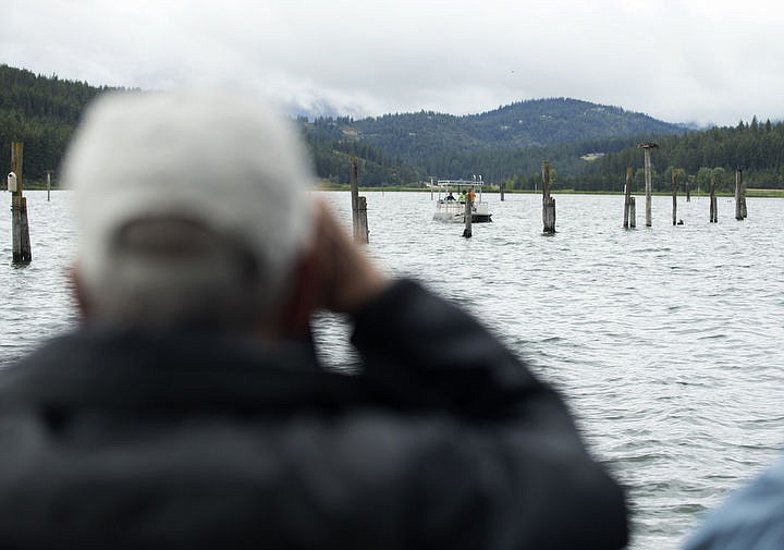 &lt;p&gt;LOREN BENOIT/Press An Osprey Cruise guest looks through his binoculars as wildlife biologists near an osprey nest on Saturday.&lt;/p&gt;