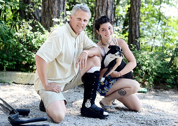 <p>Randy Passons and Kyra Wilkerson are shown with her dog Dozer on Wednesday near Hidden Harbor in Woods Bay. Passons resuscitated and saved the life of Dozer on Monday after the dog nearly drowned in Flathead Lake. Passons accomplished the life-saving effort despite being hobbled by an Achilles tendon injury.</p>