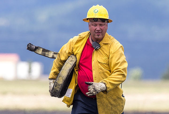 &lt;p&gt;MATT WEIGAND/Press Kelly Krause carries a muddy hose back to a fire truck after using it to extinguish a four acre brush fire in Post Falls on Friday afternoon.&lt;/p&gt;